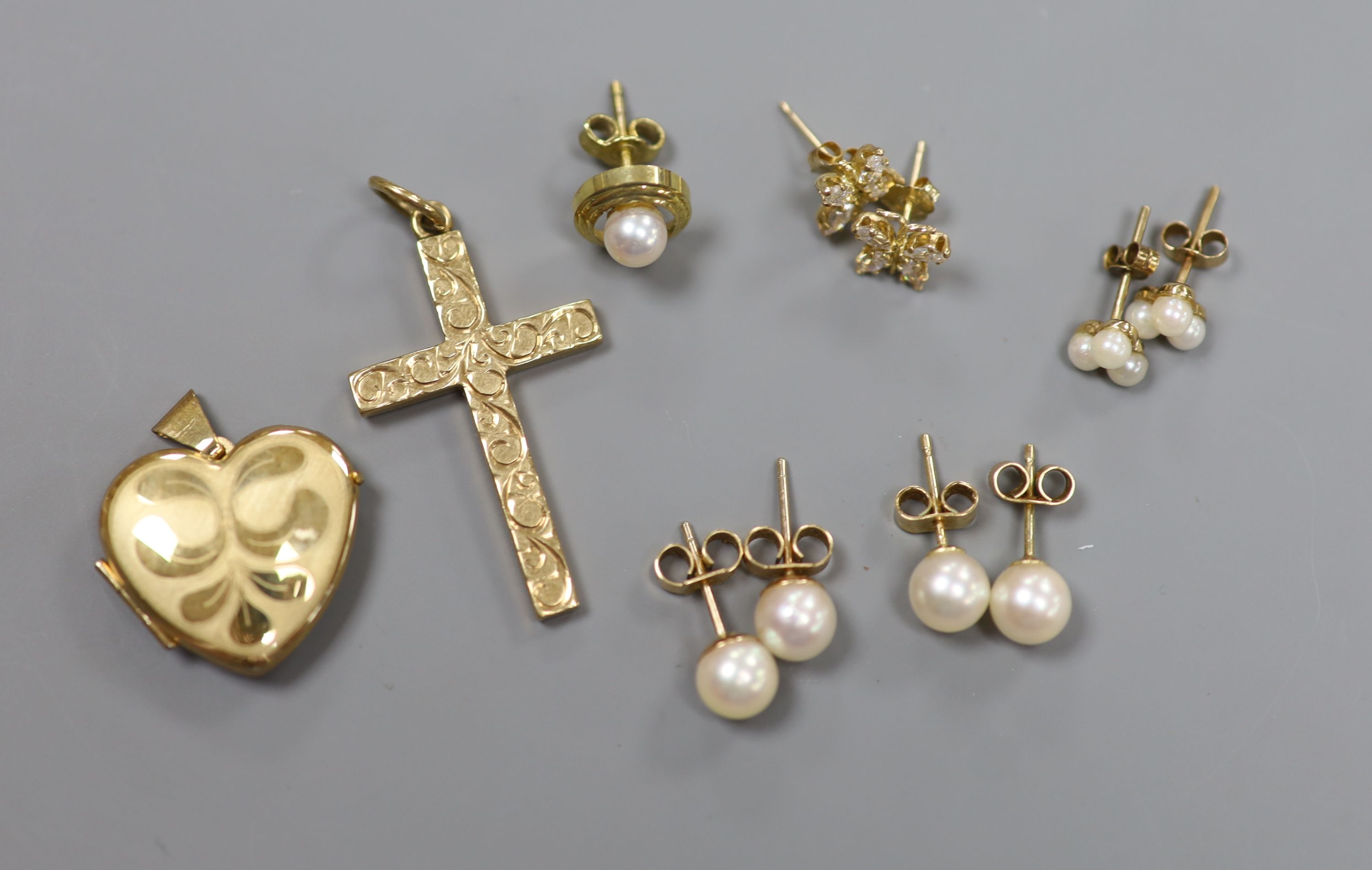A 9ct gold cross pendant, three pairs of 9ct ear studs, one odd ear stud and a 9ct gold heart pendant